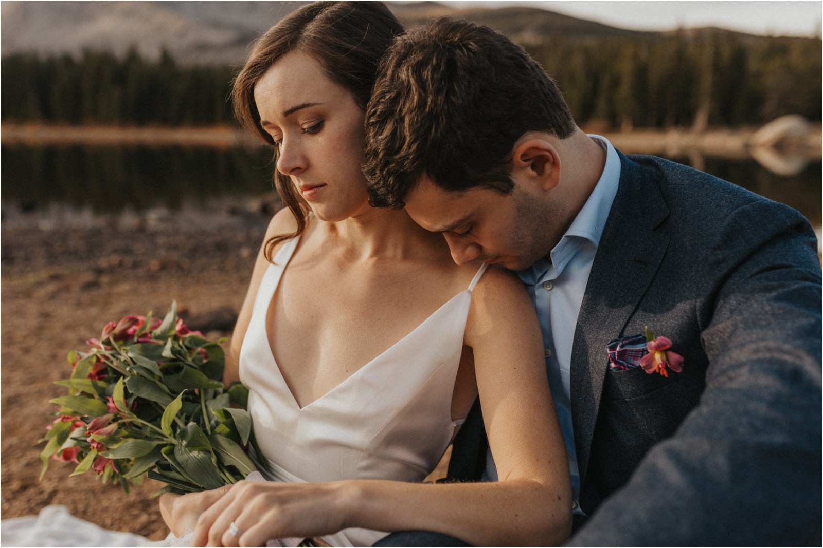 Couple embracing one another while bride is holding their bouquet, after their elopement in Colorado.