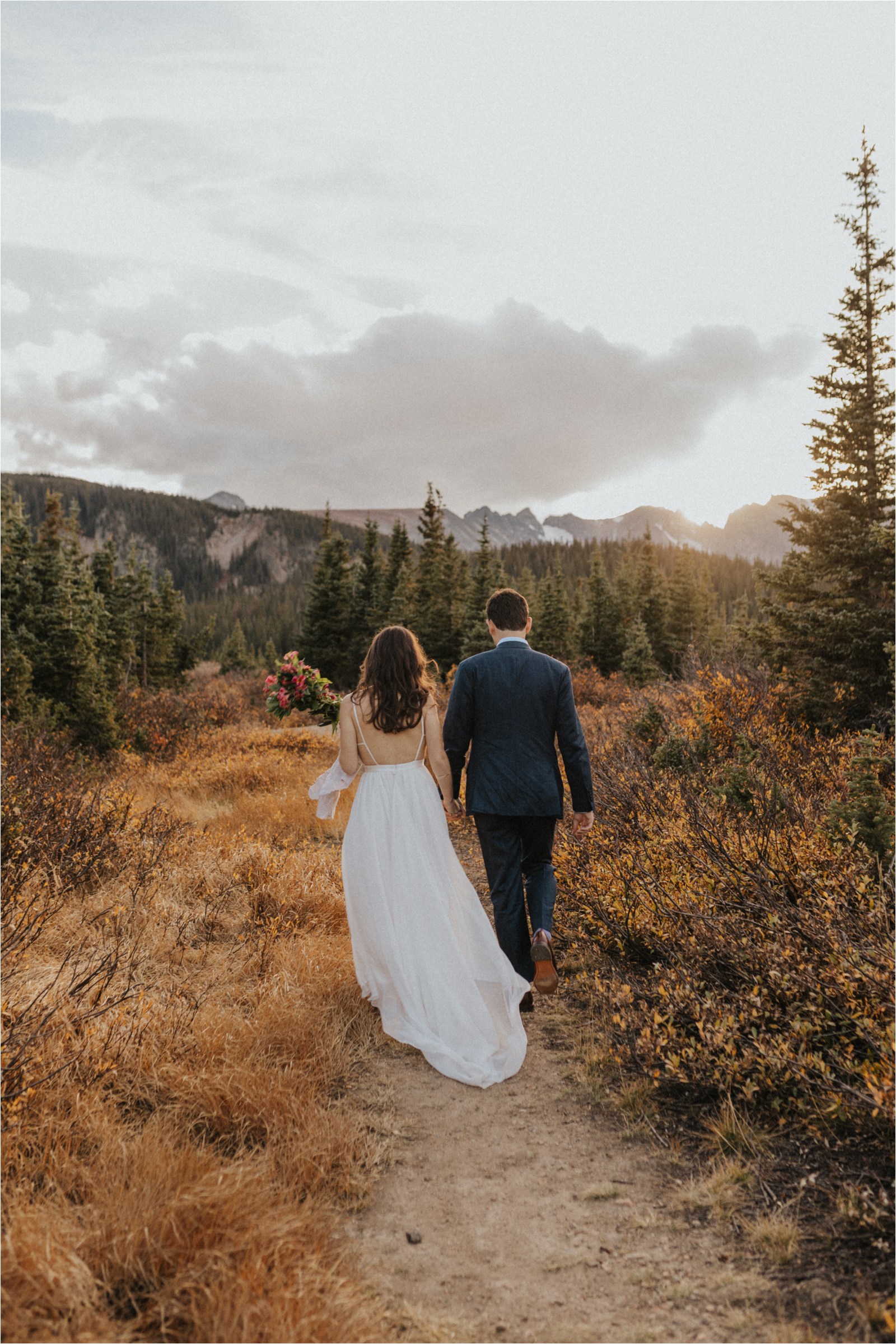 Married couple walking into the Colorado wilderness during their elopement.